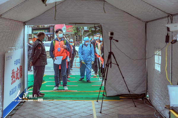 3月30日，四川省资阳市安岳中学的学生正在模拟演练进入校门口热成像通道前的消毒。